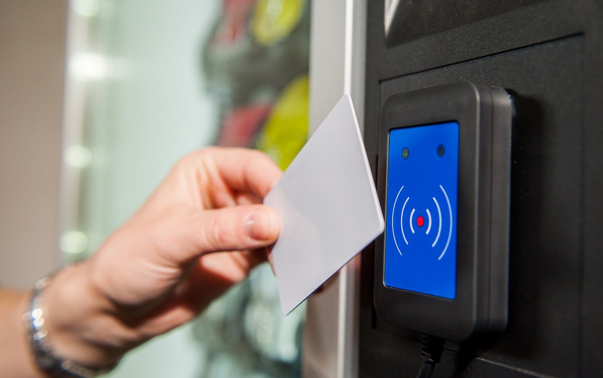 Angajat scanând cardul de acces la cititorul automatului de vending industrial OptiVEND